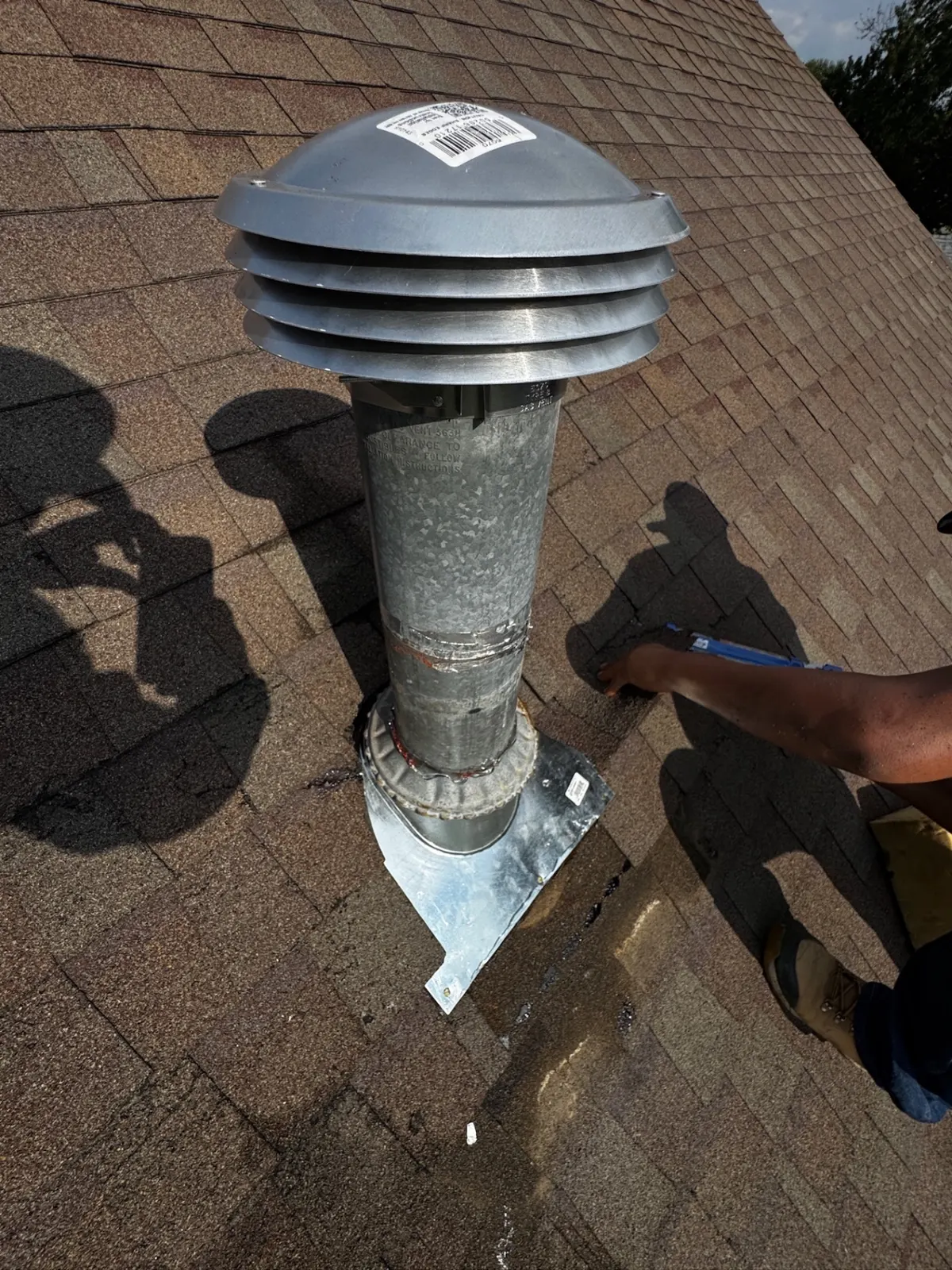 Galvanized vent stack on an asphalt shingle roof before repainting