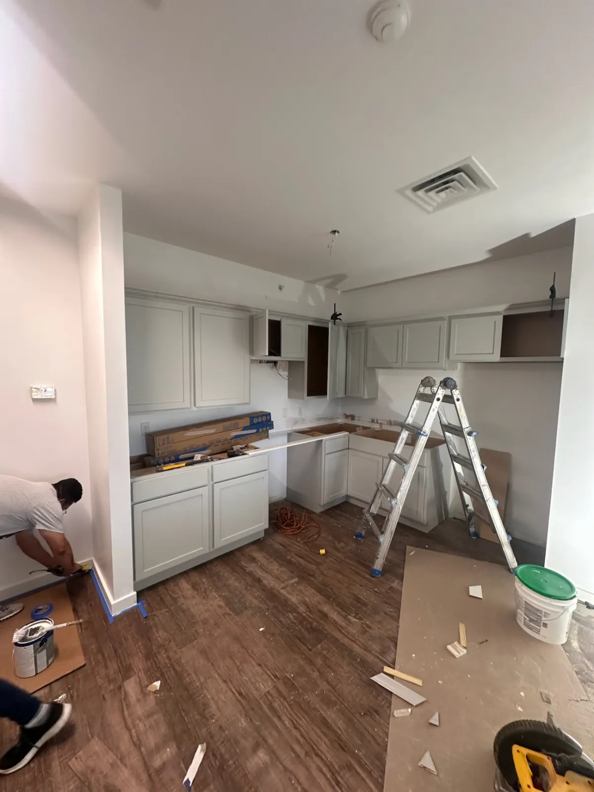 Painter finishing baseboards during the Seward kitchen remodel