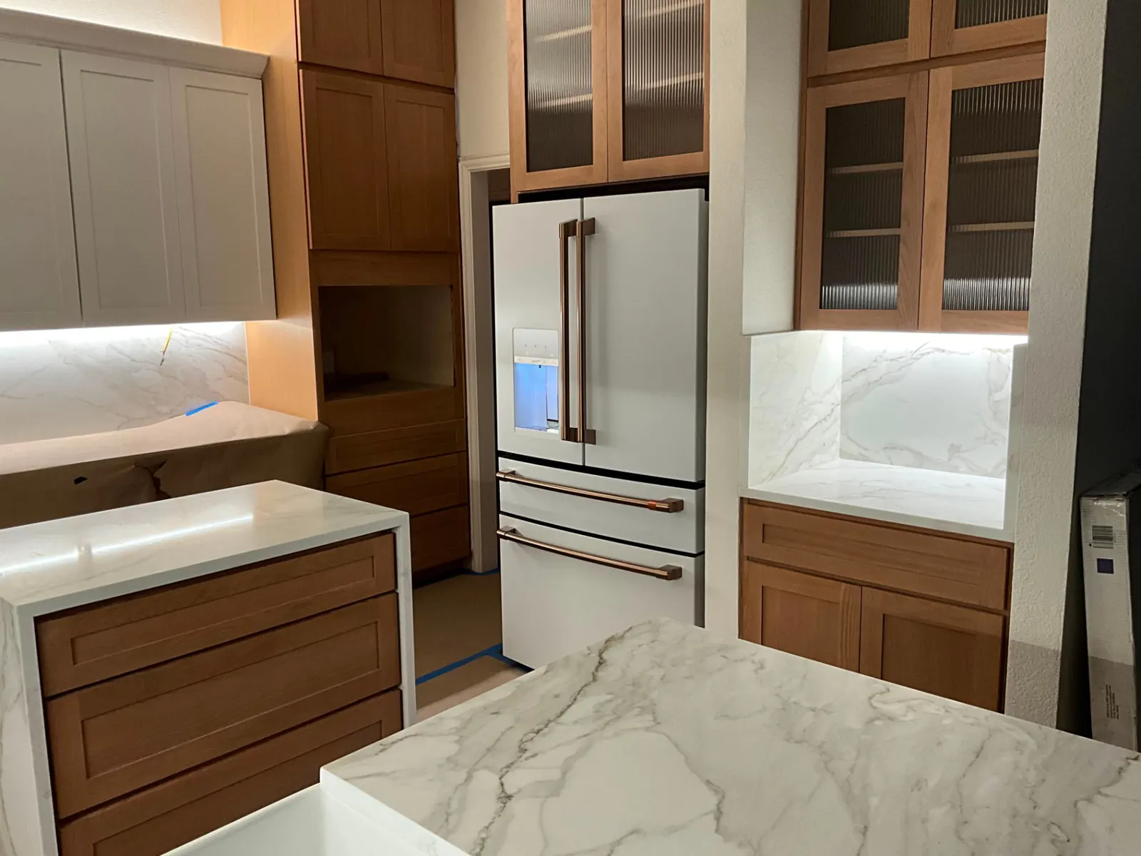 Dallas kitchen remodel with new wood cabinetry, marble backsplash, and a stainless refrigerator installed